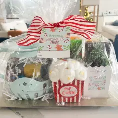 Prezentowy box tematyczny "Christmas Movie Night" zawiera słodkości, popcorn i ozdoby, idealny na wspólne wieczory filmowe.
