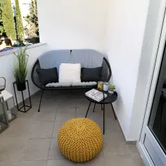 Nowy, stylowy balkon w bloku: ile kosztuje metamorfoza? Tanie pomysły i zakupy: czarna sofa, żółta pufa, latarenki.