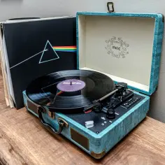 Gramofon i płyty winylowe, w tym "The Dark Side of the Moon", symbolizują powrót do łask jako ozdoby, podkreślając nostalgiczny urok i jakość dźwięku.