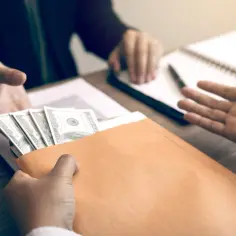 Przekazanie koperty z pieniędzmi, objawy nieuczciwych praktyk rynkowych w handlu wielkopowierzchniowym.