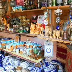 Pamiątki z Ziemi Świętej: ceramiczne naczynia, figurki wielbłądów, ozdoby z "oka proroka" i metalowe dzbanki.