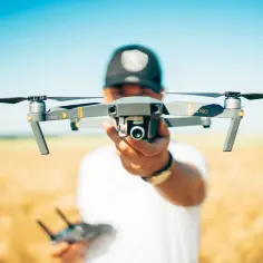 Mężczyzna trzyma drona Mavic Pro, idealnego dla początkujących. Ranking najlepszych dronów dla początkujących uwzględnia przepisy.