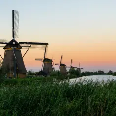 Wiatraki w Kinderdijk o zachodzie słońca. Idealne miejsce, by poczuć ducha Holandii i zastanowić się, co przywieźć z Holandii.