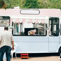 Para food trucków i handlu obwoźnego: jakie są wymogi sanepidu? Uroczy food truck z lodami, para klientów.