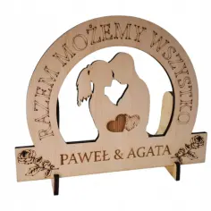 Drewniana statuetka z grawerem "RAZEM MOŻEMY WSZYSTKO" i imionami "PAWEŁ & AGATA", z sylwetką pary i sercami.