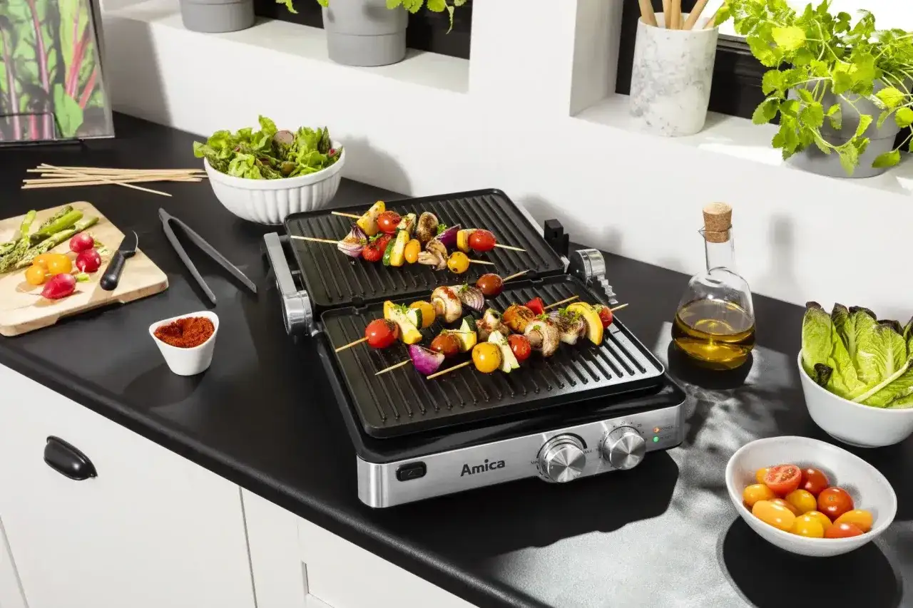 Grill elektryczny Amica z szaszłykami warzywnymi i mięsnymi – idealne gadżety kuchenne na prezent dla amatora gotowania.