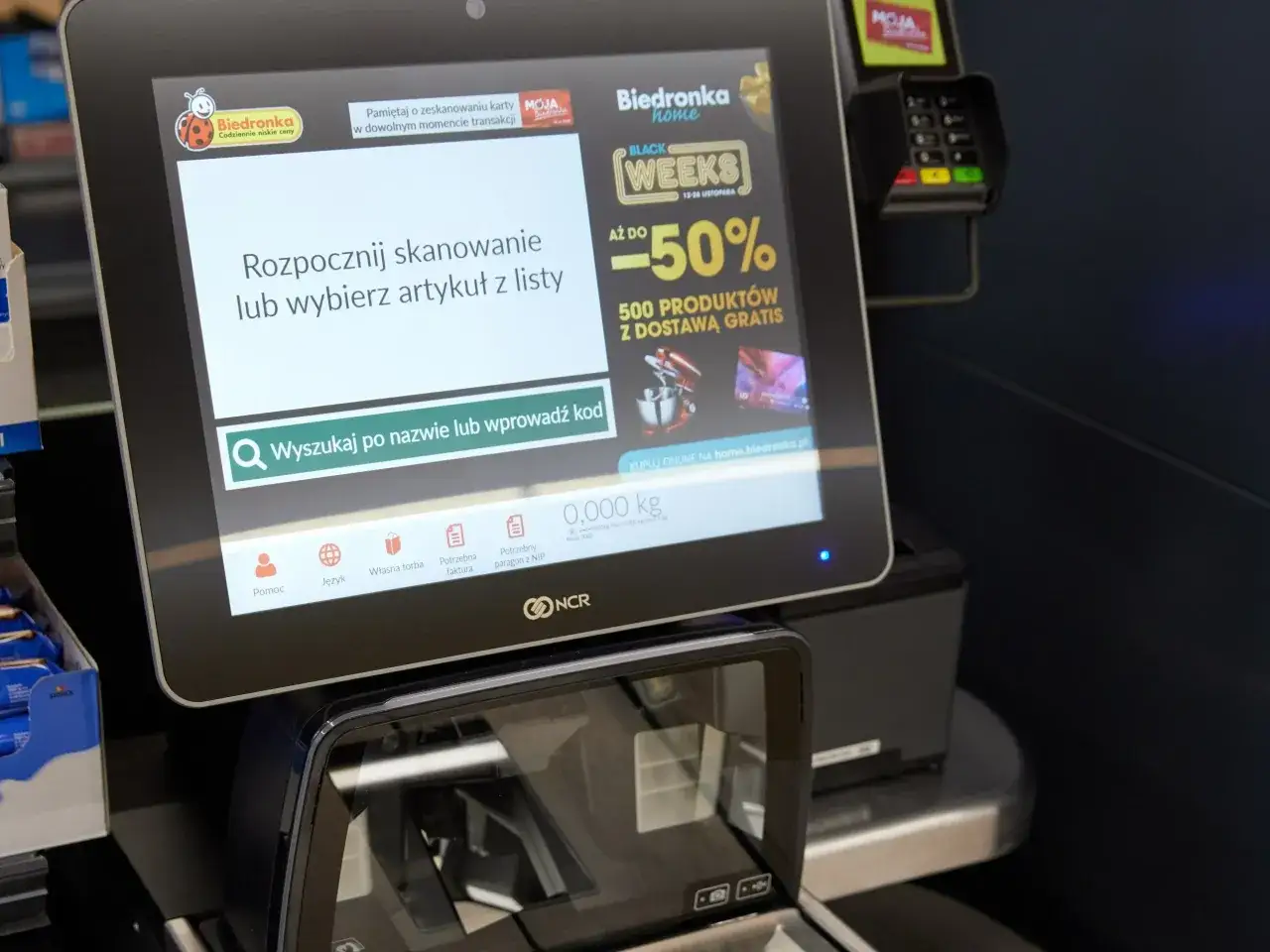 Kasa samoobsługowa Biedronka. Automatyzacja handlu a zatrudnienie – ekran zachęca do skanowania produktów.