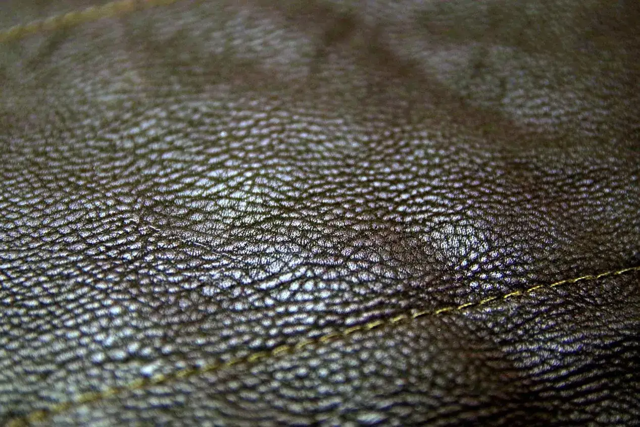 Zbliżenie na fakturę skóry, która pomoże Ci odróżnić skórzane buty od syntetycznych zamienników eco-leather. Widoczna nić.
