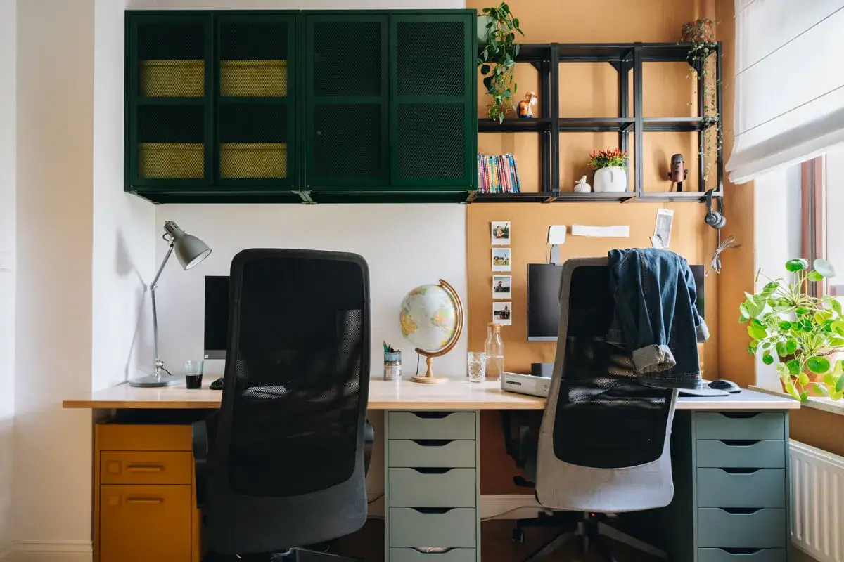 Inspiracje Pinterest: jak urządzić domowe biuro w małym mieszkaniu. Dwa stanowiska pracy z wygodnymi fotelami, biurkiem i wiszącymi szafkami.