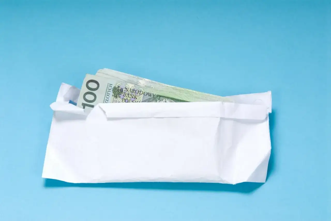 Koperta z banknotami 100 zł. Czy to dobry pomysł na prezent dla nastolatka? Opinie są podzielone.