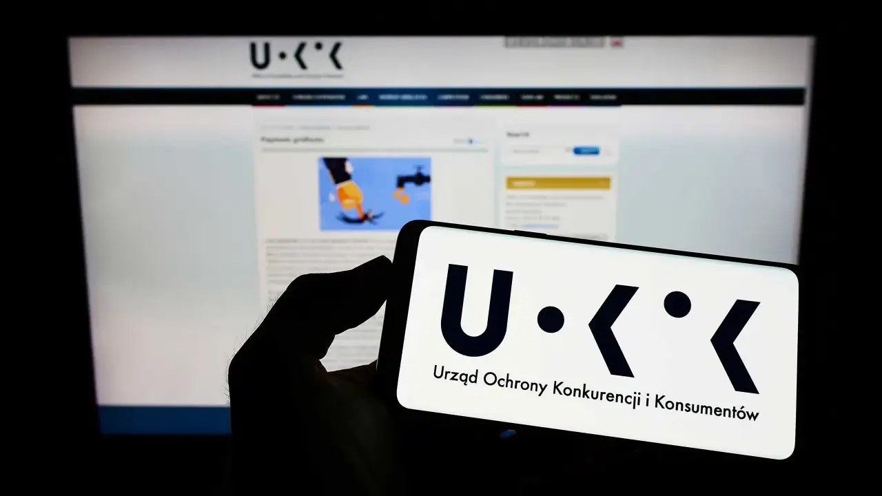 UOKiK bada objawy manipulacji w rankingach, np. płatny artykuł sponsorowany. Logo UOKiK na ekranie telefonu i komputera.