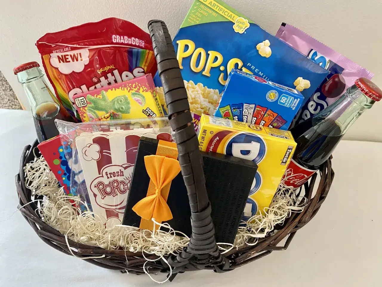 Prezentowy box na wieczór filmowy: popcorn, słodycze, napoje i karta podarunkowa. Idealny pomysł, jak zrobić prezentowy box tematyczny typu movie night w domu.