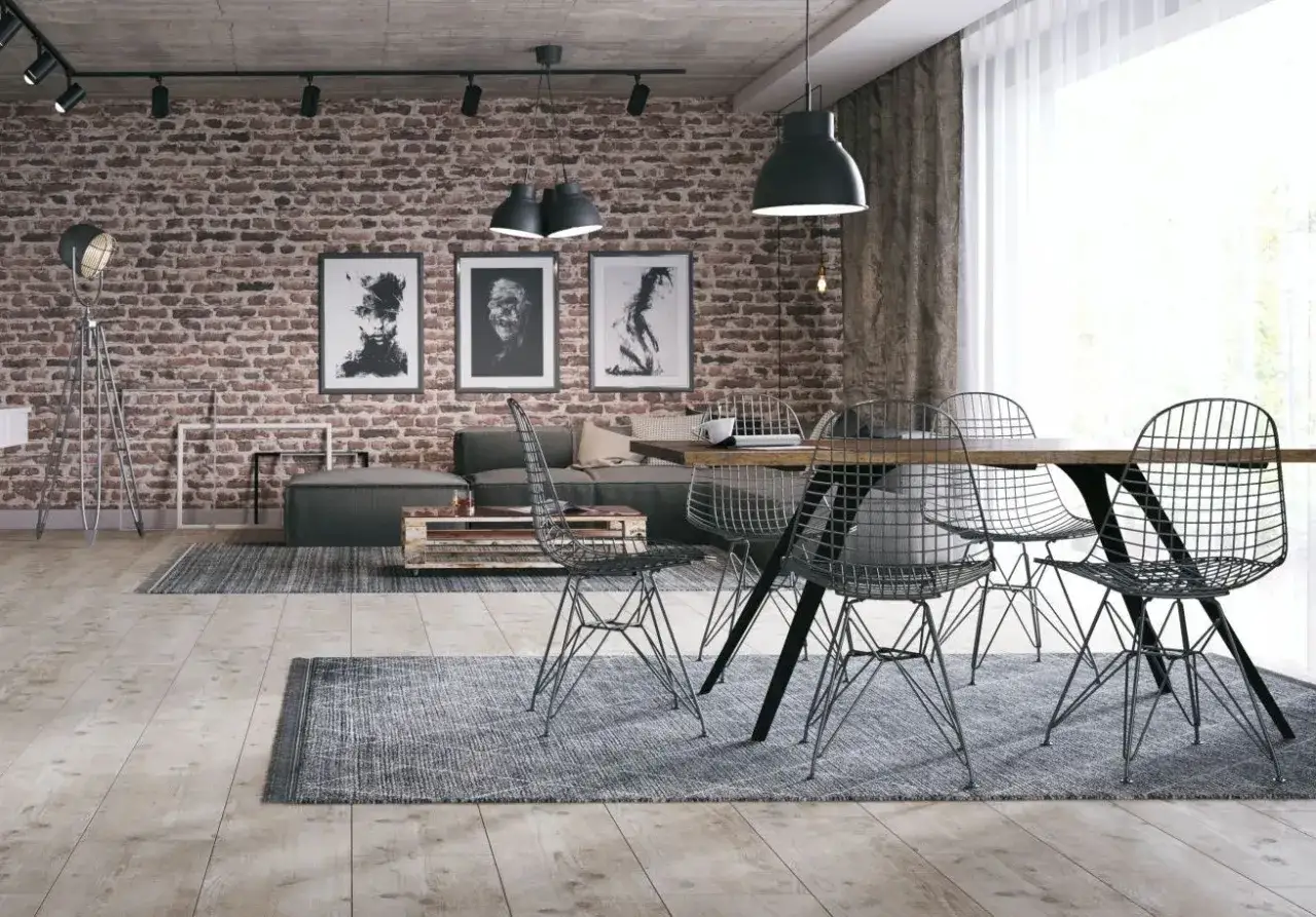 Styl loftowy w bloku: ceglana ściana, betonowy sufit, metalowe krzesła i sztuka. To połączenie tworzy industrialny klimat, który tak cenią mieszkańcy.