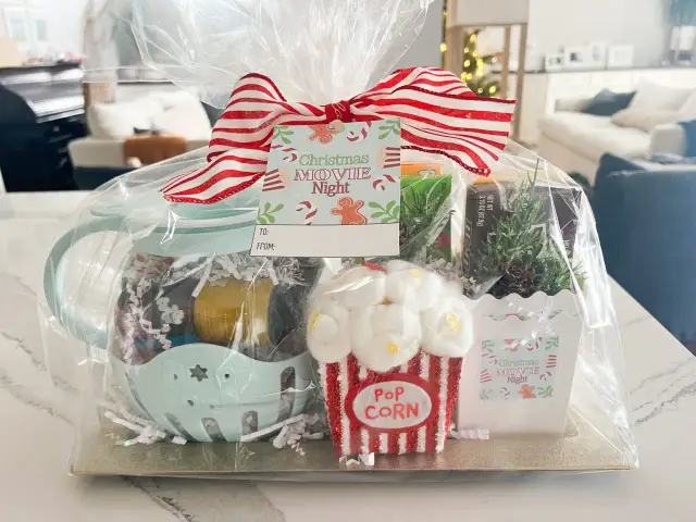 Prezentowy box tematyczny "Christmas Movie Night" zawiera słodkości, popcorn i ozdoby, idealny na wspólne wieczory filmowe.